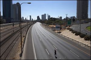 A woman runs along the car-free Ayalon expressway, during the holiday of Yom Kippur in Tel Aviv, Wednesday. Israelis are marking the holiday of Yom Kippur, or 'Day of Atonement,' which is the holiest of Jewish holidays when observant Jews atone for the sins of the past year and the Israeli nation comes to almost a complete standstill. 