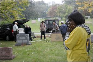 Kayla McCadney turned away from as the casket of her daughter, Iesha McCadney, was loaded in a vehicle after being exhumed Wednesday morning at Woodlawn Cemetery in Toledo.