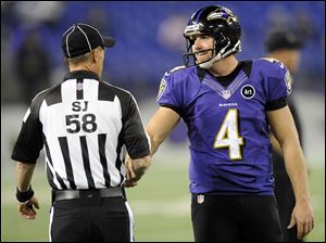 Side judge Jimmy DeBell shakes hands with Ravens punter Sam Koch.