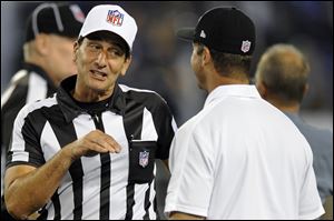 Referee Gene Steratore, left, talks with Baltimore Ravens head coach John Harbaugh before Thursday's game in Baltimore.