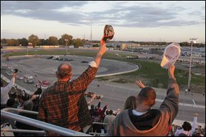 Fans raise their hats to the drivers at the start of Saturday night's race at Toledo Speedway. The fans in attendance were treated to a wild finish.