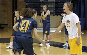 UT senior and team captain Naama Shafir, left, slaps hands with graduate assistant/manager Jessica Slagle during practice Tuesday at UT's Savage Arena.