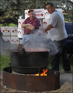 Bob Bailey of Grand Rapids, Ohio, watches Joe McFarland of McClure, Ohio, stir apple butter at Kryder Farm in McClure, Ohio, in preparation for the Grand Rapids Applebutter Fest from 10 a.m. to 5 p.m. Oct. 14. 