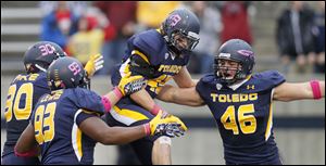 Toledo safety Mark Singer, 43, center, celebrates his second interception in as many weeks for the Rockets.