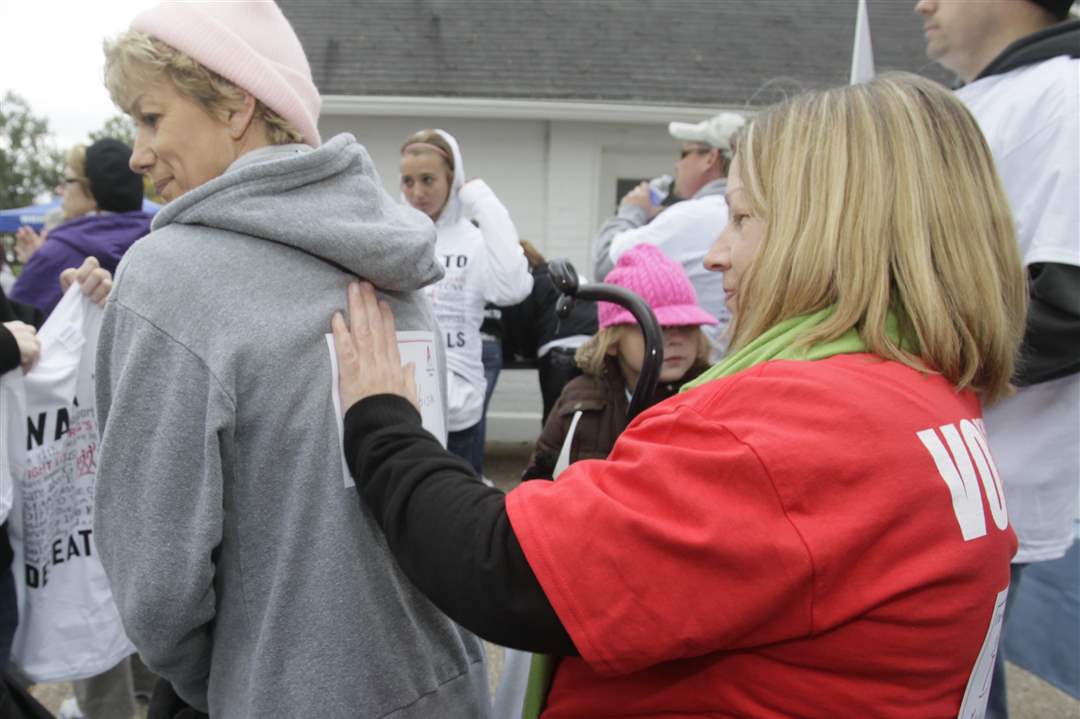 Jan-Miller-of-Bellvue-left-gets-help-putting-on-her-sign-1