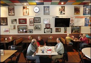 Miller Brothers Construction colleagues Dennie Hines, left, Larry Winkleman, center, and Terry Moore, right, talk while they wait to pay for their lunches at Ickey's restaurant in downtown Archbold.