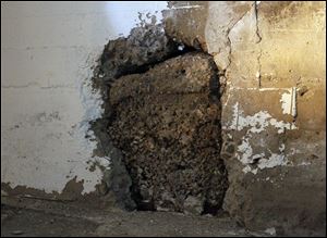 A portion of the basement wall is deteriorating because of moisture that has collected since the power has been shut off.