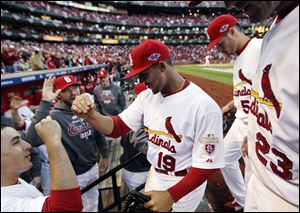 St. Louis Cardinals center fielder Jon Jay is congratulated by teammates as he returns to the dugout after catching a fly ball at the warning track to retire Washington Nationals' Danny Espinosa during the sixth inning.