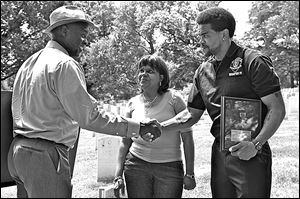 Tukufu Zuberi, left, at Arlington Cemetery meets with Tara Johnson and DeMarqus Townsend, descendants of one of the men honored in his World War I poster, Our Colored Heroes. 