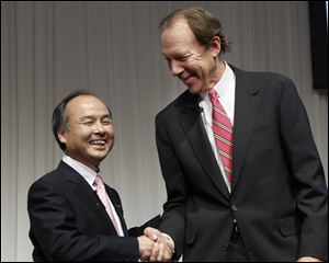 Softbank Corp. President Masayoshi Son, left, and Sprint Nextel Corp. Chief Executive Dan Hesse shake hands during their joint press conference in Tokyo.