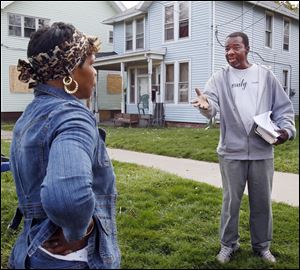 Deacon Zettie Williams, right, tries to encourage a Mayville Place resident to join a neighborhood group Thursday.