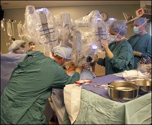 Dr. Matthew Fourman, far right, and his team use the da Vinci Surgery system on his patient.