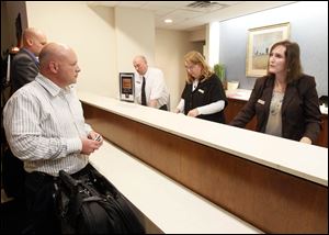 Overnight guest Don Welker, left, from New Jersey, checks in with Laura Roman, Front Office Manager, right,  in the lobby of the Toledo Hilton where Vice President Joe Biden is staying overnight.