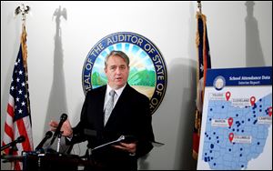 State auditor of Ohio Dave Yost goes over the School Attendance Data Interim Report during a press conference in his Columbus office.