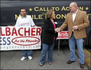 Amy Kremer, chairman of the Tea Party Express, shakes hands with Samuel Wurzelbacher in front of the Tea Party Express bus on Tuesday.