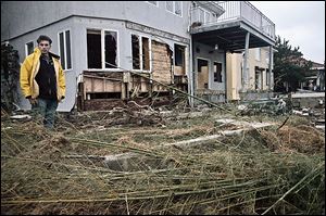 Carlo Popolano stands outside his beachfront home, damaged in superstorm Sandy, in Coney Island's Sea Gate community in New York. He said 'everything was okay until about 7:30 and then one big wave came and washed away our whole backyard.'