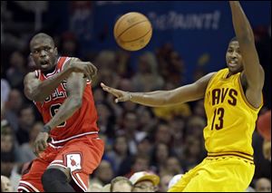 Chicago Bulls' Luol Deng saves the ball from going out of bounds, next to Cleveland Cavaliers' Tristan Thompson in the third quarter tonight in Cleveland.