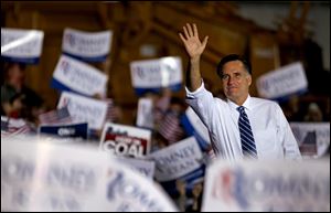 Republican presidential candidate Mitt Romney waves to supporters as he takes the stage to speak at a campaign event today at Screen Machine Industries in Etna, Ohio.