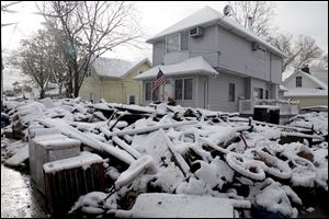 A pile of garbage in the street is covered with snow in the New Dorp section of Staten Island, N.Y.