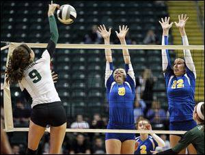 St. Ursula Academy players Emily Lydey, 9, and Lauren Daudelin, 12, try to block the shot of Cincinnati Ursuline player Paige Kebe, 9, during the third set of their Division I semi-final match of the Ohio State Volleyball Championship at Wright State University's Nutter Center.