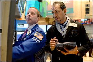 Robert Nelson II of Barclays, left, and Fady Tanios of Raven Securities work on the floor of the New York Stock Exchange, in New York.