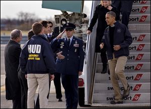 President Barack Obama, followed by Sen. Kirsten Gillibrand, D-N.Y. and Sen. Charles Schumer, D-N.Y., is greeted by, from left, New York City Mayor Michael Bloomberg, Housing and Urban Development Secretary Shaun Donovan, back to camera, and New York Gov. Andrew Cuomo, upon their arrival at JFK International Airport in New York today.