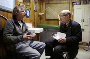 Dr. Russell Dohner, right, talks with patient Joe Logsdon about his high cholesterol in Rushville, Ill. Patients line up early outside his office just off the town square, waiting quietly for the doctor to arrive, as he has done for nearly 60 years.