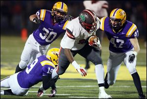 Central Catholic's Keith Trowbridge (89) runs the ball against   Avon defenders Zack Torbert (19), Cory Ohradzansky (30) and Kevin Maloney (47) during a Division II  regional final football game in Clyde, Ohio. Central Catholic won 42-14.