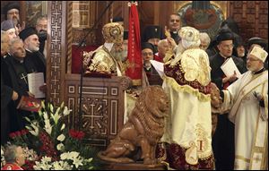 Pope Tawadros II, 60, sits on the throne of St. Mark, the Coptic church's founding saint, wearing the papal crown, during an elaborate ceremony lasting nearly four hours, attended by the nation's Muslim prime minister and a host of Cabinet ministers and politicians, in the Coptic Cathedral in Cairo, Egypt.