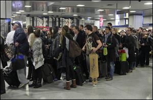 Passengers wait to board a train in New York's Penn Station, Wednesday. Around 43.6 million Americans were expected to journey 50 miles or more between Wednesday and Sunday, just a 0.7 percent increase from last year, according to AAA's yearly Thanksgiving travel analysis.