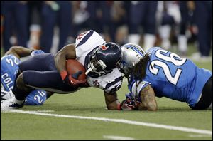 Houston Texans running back Justin Forsett is hit by Detroit Lions free safety Louis Delmas (26) during the third quarter today at Ford Field in Detroit. Forsett scored an 81-yard touchdown on the controversial paly.