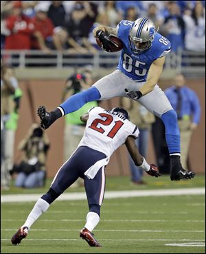 Detroit Lions tight end Tony Scheffler jumps over Houston Texans defensive back Brice McCain.