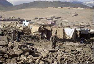 A U.S. soldier stands guard at the site of suicide attack in Wardak Province of Kabul Afghanistan.