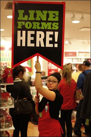 Jessica Ramirez, a salesman at Bath and Body Works, helps direct customers at Westfield Franklin Park.