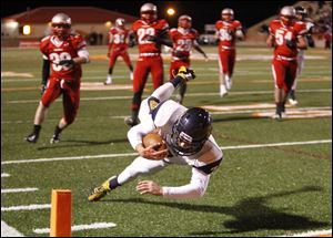 Whitmer High School quarterback Nick Holley, 7, dives into the end zone. Holley rushed for 249 yards on 27 carries in the game.