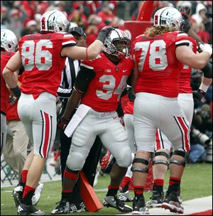 Ohio State TB Carlos Hyde (34) celebrates scoring a touchdown against  Michigan with Jeff Heuerman (86) and Andrew Norwell (78) during the first quarter Saturday, in Columbus, Ohio. 