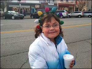 Aubrey Hill of Perrysburg stays warm with hot chocolate as she waits for the Home for the Holidays parade to begin Sunday in downtown Perrysburg.