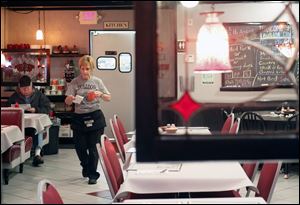 Server Chris Skadland works the dining area during breakfast at Bulldog Diner in Rossford. Owner Rob Socie is pondering how to market to casino customers.