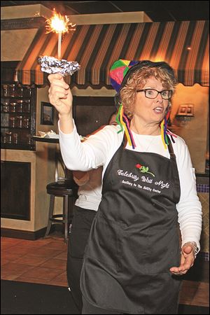 The Ability Center Auxiliary president Claire Browning leads the dessert parade at the celebrity wait night.