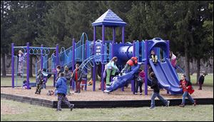 Third graders enjoy the new playground equipment at Fairfield School in Maumee.