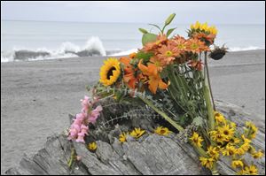 Flowers are rest on a large drift log yards from the breaking surf of the Big Lagoon beach near Trinidad, Calif., Monday.