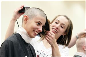 Briana D’Entremont, 19, has her head shaved by Haylee Keel of Honeycomb Salon and Spa during a fund-raiser for St. Baldrick’s Foundation, which funds childhood cancer research grants, at BGSU.