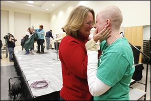 Ann Schlosser, hugs her daughter Megan, left, after Megan had her head shaved. Mrs. Schlosser has Stage 4 cancer and was given three months to live by her doctors. Four years later, she is still fighting.