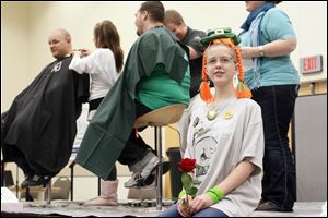 Connie Christiansen, a sixth-grader at Perrysburg Junior High School, sits on the stage after having her head shaved for a fund raiser for St. Baldrick's Foundation, which funds childhood cancer research grants.