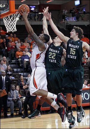  A'uston Calhoun, who led Bowling Green with19 points, goes to the basket against Wright State's Cole Darling (22) and Kendall Griffin (15) in Monday night's game at the Stroh Center.