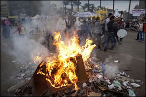 Protesters opposed to Egyptian President Mohammed Morsi chant slogans near burning garbage at Tahrir Square in Cairo, Egypt, today.