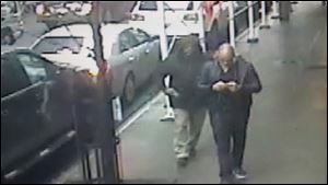 This still image made from a video provided by the New York City Police Department shows the gunman, left, behind Brandon Lincoln Woodard pulling the weapon from his jacket pocket a moment before the shooting, Mon. Dec. 10, 2012 in New York. A security camera photo shows a man pulling a weapon from his pocket moments before police say he shot a Los Angeles man in midtown Manhattan. The NYPD released the photo Tuesday amid a manhunt for the unidentified suspect in the execution-style slaying (Ap Photo/New York Police Department/ HO)