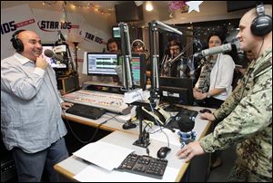 Star 105 radio host Andrew Zepeda, left,  chats with 1st Class PO Eric Luffy on the air before he surprises his family with an early holiday homecoming. 