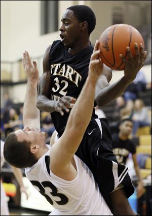 Start’s Scott Hicks, right, looks to pass while Perrysburg’s Hatden Thomas defends during their game Saturday night. Hicks and Dexter Johnson both scored 14 points in the road victory.