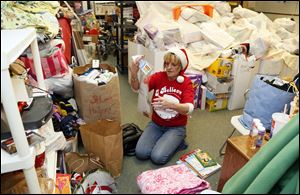 Volunteer Kim Fisher sorts through toys before a Christmas party at Helping Hands of St. Louis in Toledo.